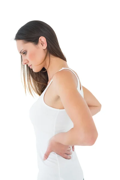 Casual young woman suffering from back pain — Stock Photo, Image