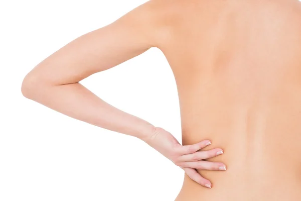 Rear view of a fit topless woman with back pain — Stock Photo, Image