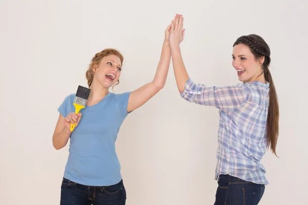 Two cheerful young female friends giving high five — Stock Photo, Image