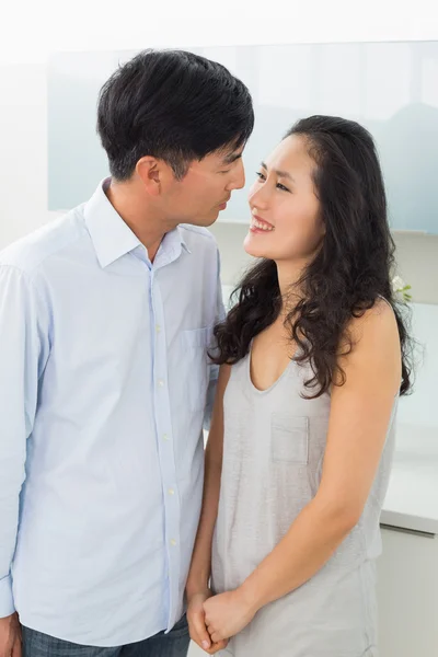 Side view of a romantic young couple in kitchen — Stock Photo, Image