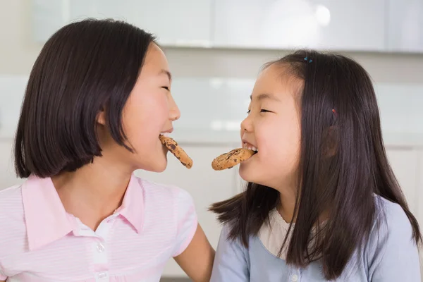 Dvě dívky, které se těší soubory cookie v kuchyni — Stock fotografie