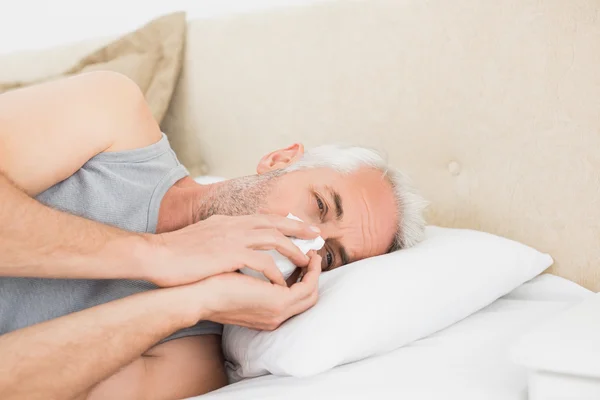 Nahaufnahme eines an Erkältung leidenden reifen Mannes im Bett — Stockfoto