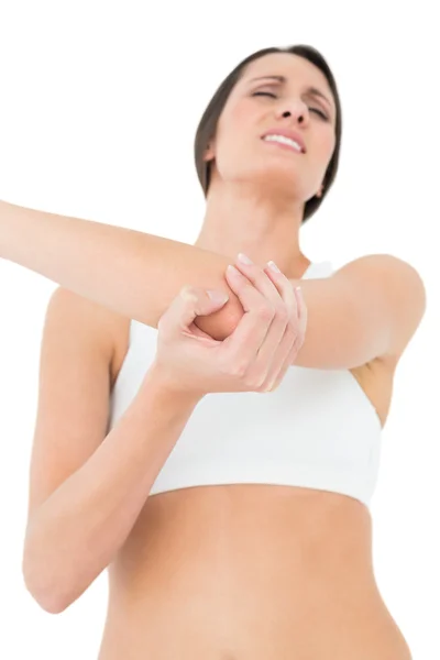 Low angle view of a fit young woman with elbow pain — Stock Photo, Image