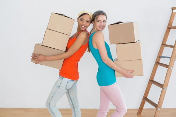 Vrouwelijke vrienden samen bewegen in een nieuw huis — Stockfoto