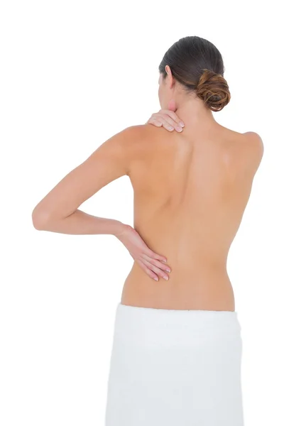 Rear view of a topless fit woman with shoulder pain — Stock Photo, Image