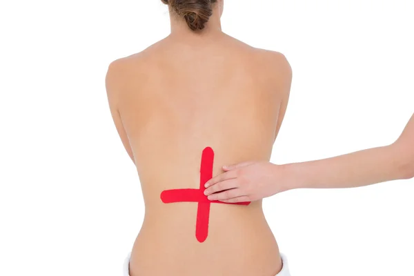 Topless fit woman with red cross sign on back — Stock Photo, Image