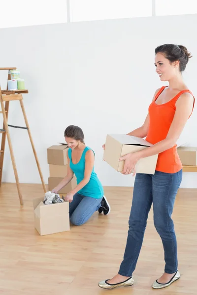 Two friends moving together in a new house — Stock Photo, Image