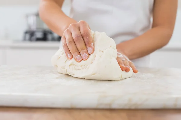Mid section of a woman kneading dough in kitchen — Stock Photo, Image