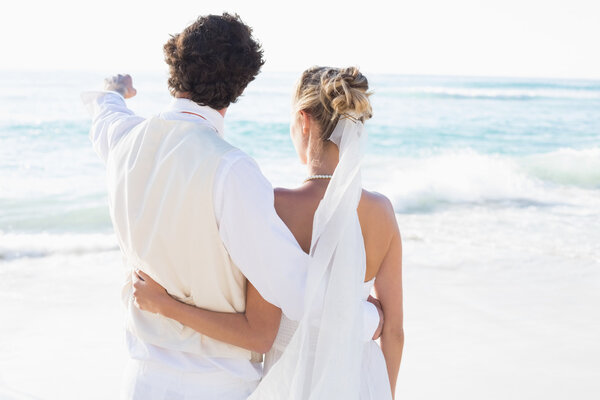 Newlyweds standing by the sea