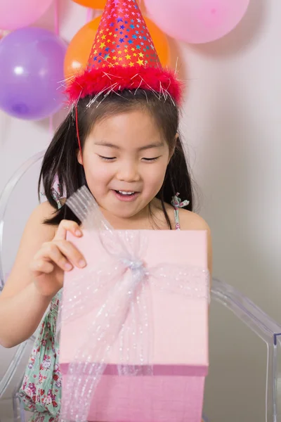 Menina abrindo caixa de presente em sua festa de aniversário — Fotografia de Stock