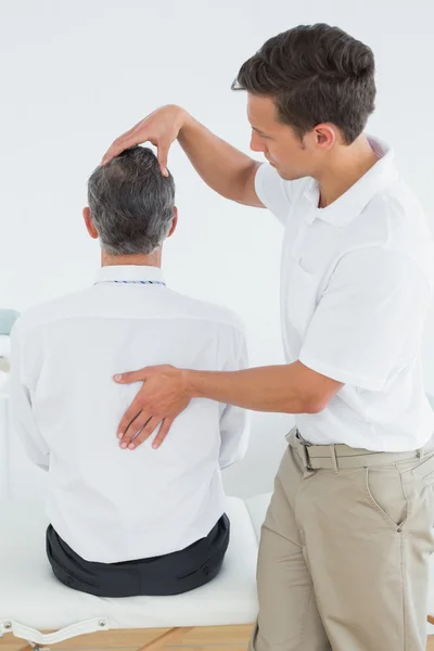 Manliga kiropraktor undersöka mogen man — Stockfoto