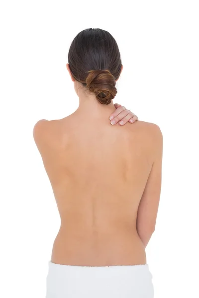 Rear view of a topless fit woman with shoulder pain — Stock Photo, Image