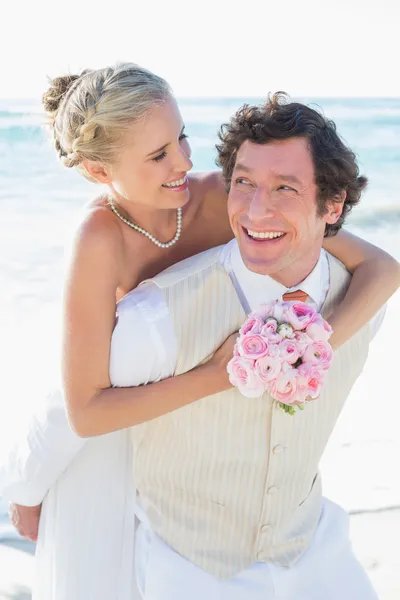 Knappe bruidegom geven zijn nieuwe vrouw een piggy back — Stockfoto
