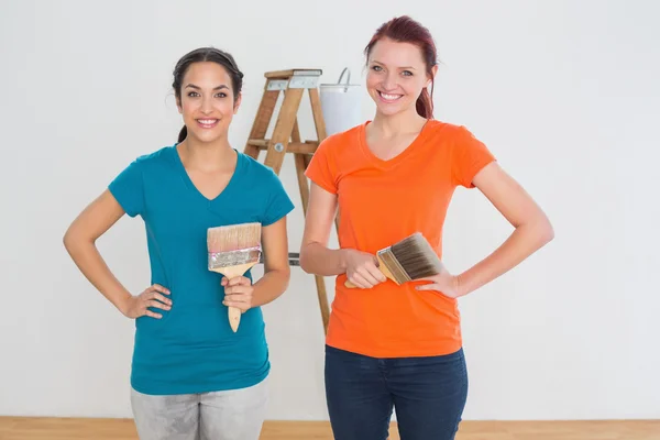 用油漆刷子和一座新房子里的梯子的朋友 — 图库照片