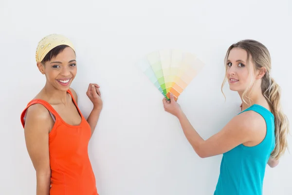 Amici femminili che scelgono il colore per dipingere una stanza — Foto Stock