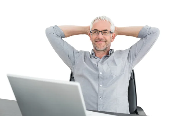 Empresário sentado com as mãos atrás da cabeça e laptop — Fotografia de Stock