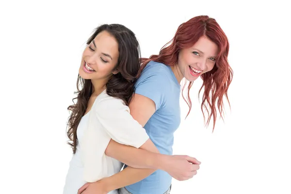 Young women standing back to back with interlocked hands — Stock Photo, Image
