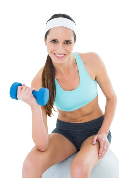 Mujer en forma de ejercicio con mancuerna en la pelota de fitness — Foto de Stock