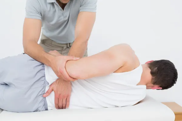 Fisioterapeuta masculino examinando paciente — Foto de Stock