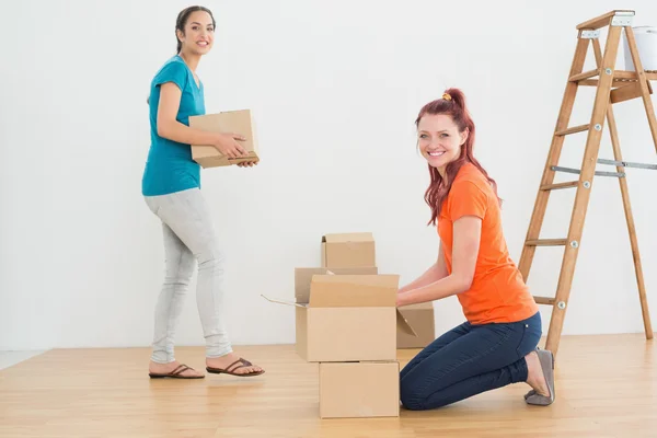 Portrait of two friends moving together in a new house — Stock Photo, Image