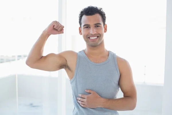 Porträt eines fitten Mannes, der im Fitnessstudio die Muskeln spielen lässt — Stockfoto