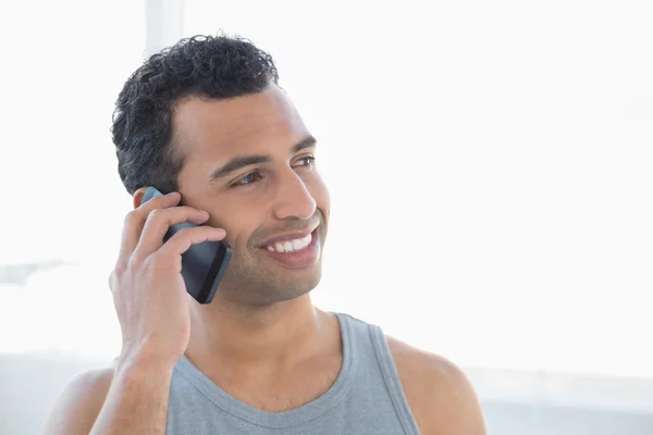 Close-up van een glimlachende jongeman met behulp van mobiele telefoon — Stockfoto