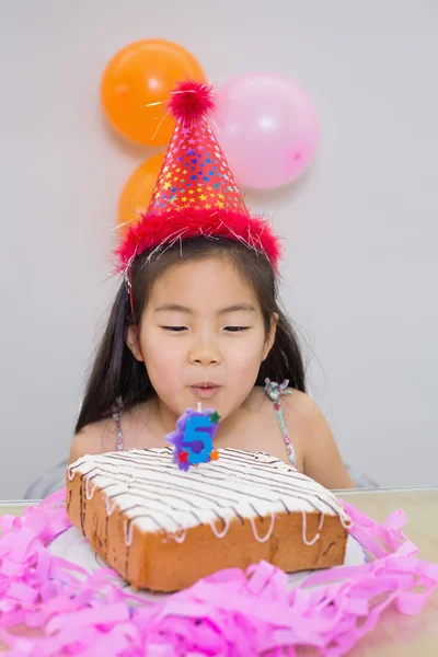 Schattig klein meisje waait haar verjaardag cake — Stockfoto