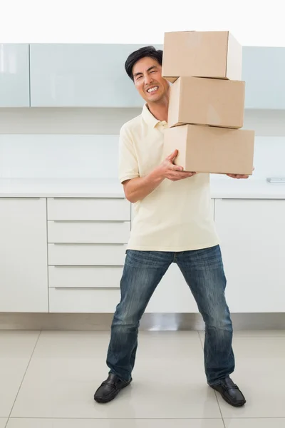 Full length of a casual young man carrying boxes — Stock Photo, Image