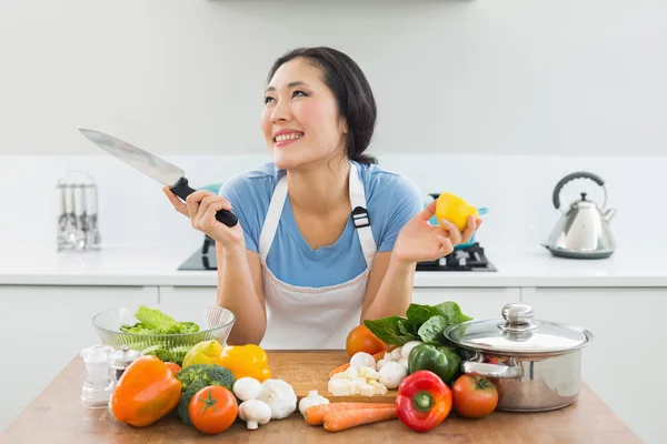 Doordachte vrouw hakken groenten in de keuken — Stockfoto