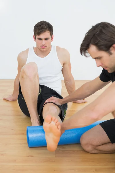 Physiothérapeute examinant une jambe de jeunes hommes — Photo
