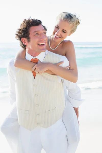Glückliche Braut bekommt ein Huckepack zurück von hübschen Ehemann — Stockfoto