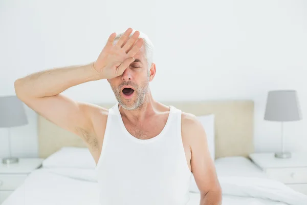 Reifer Mann gähnt im Bett — Stockfoto