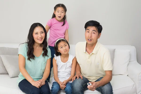 Retrato de uma família de quatro assistindo tv na sala de estar — Fotografia de Stock