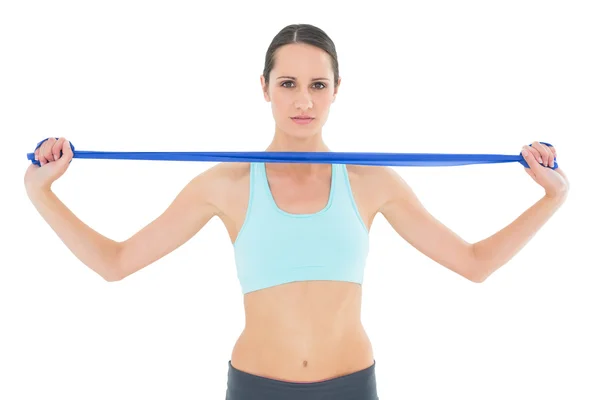 Joven en forma seria sosteniendo cinturón de yoga azul — Foto de Stock