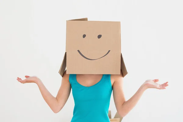 Mujer en camiseta azul con caja de cartón sonriente en la cara — Foto de Stock