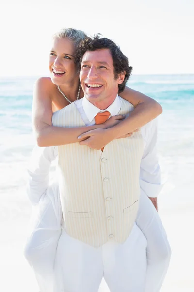 Happy bride getting a piggy back from handsome husband — Stock Photo, Image