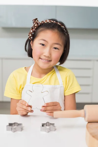 Sorridente giovane ragazza che tiene stampo per biscotti in cucina — Foto Stock