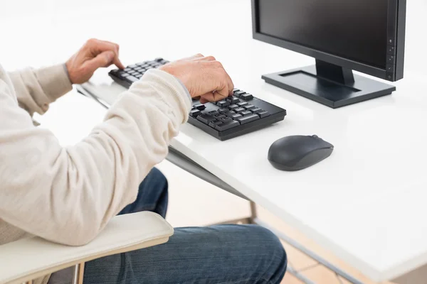 Side view mid section of a man using computer keyboard — Stock Photo, Image