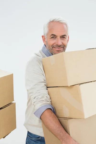 Portrait of a smiling mature man carrying boxes — Stock Photo, Image