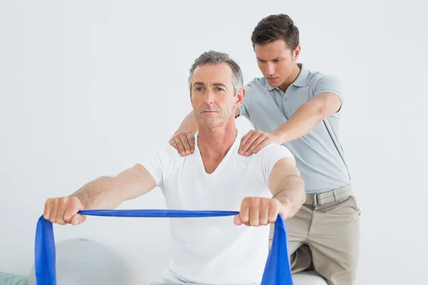 Therapist massaging mans shoulder in gym hospital — Stock Photo, Image