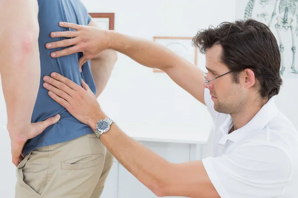 Mid section of a physiotherapist examining mans back Royalty Free Stock Photos