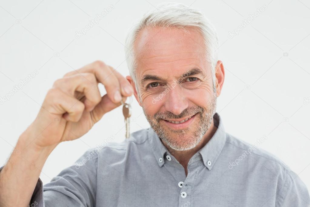 Close-up portrait of a smiling mature man holding house keys