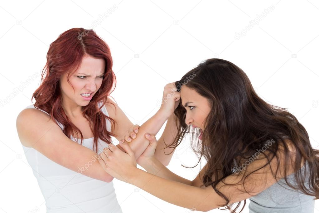 Angry young woman pulling female's hair in a fight