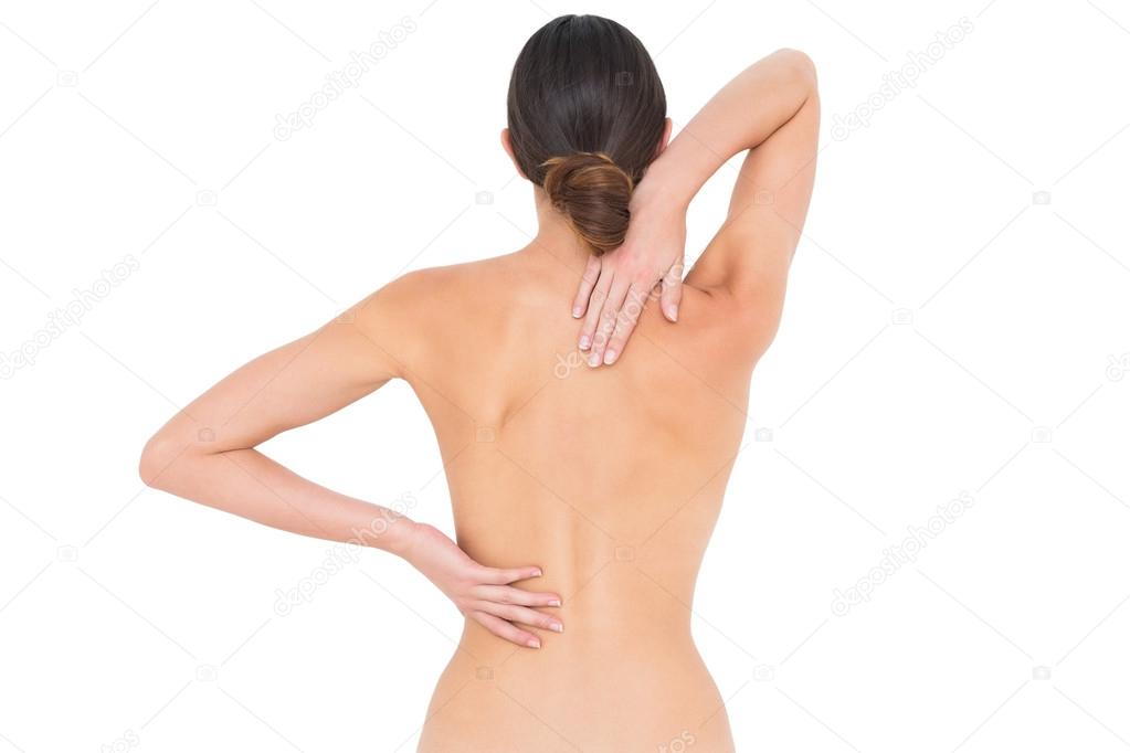 Rear view of a fit topless young woman with back pain