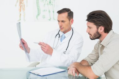 Male doctor explaining spine x-ray to patient