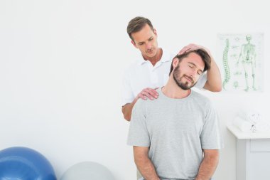 Male chiropractor doing neck adjustment clipart