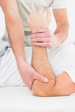 orta bölümde bir erkek eli inceleyerek bir fizyoterapist