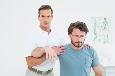 genç bir adamın kol germe erkek fizyoterapist