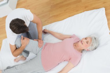 fizyoterapist kıdemli kadının bacak incelenmesi