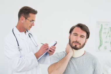 erkek Doktor hastanın burkulan boyun incelenmesi
